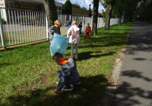 grupa sprząta okolice przedszkola ze śmieci